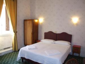 a hotel room with a bed and a dresser at Hotel Texas in Rome