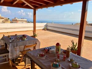 2 mesas en un balcón con vistas al océano en Sicania, en Patti