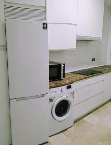a kitchen with a washing machine and a microwave at La Casa del Arte in Cádiz +21 photos