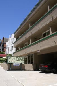 ロサンゼルスにあるロイヤル パレス ウエストウッド ホテルの駐車場前の看板のある建物