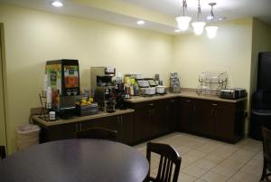 a kitchen with a table and a counter with a coffee shop at Royal Palace Westwood Hotel in Los Angeles
