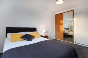una camera da letto con un grande letto con cuscini gialli di Shell a Loughborough