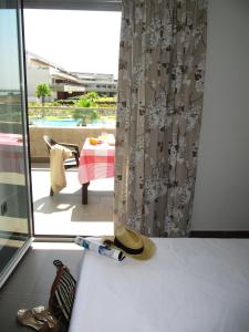 a hat sitting on a bed next to a window at Life Apartments El Rompido in El Rompido