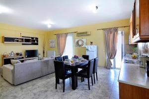 a kitchen and living room with a table and a couch at Vasos Apartment Agios Athanasios Corfu in Agrós