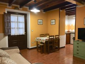 a living room with a table and a kitchen at Apartamentos Palombina in Celorio
