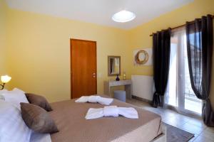 a bedroom with two towels on a bed with a window at Vasos Apartment Agios Athanasios Corfu in Agrós