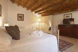 a bedroom with a white bed and a television at Atenea Luxury Suites - Atenea Collection in Agrigento