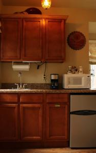 a kitchen with wooden cabinets and a microwave at The Grand Treehouse Resort in Eureka Springs