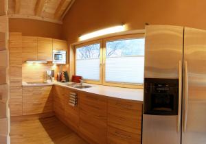 een keuken met houten kasten en een koelkast bij Gasthaus-Pension Reiterklause in Leutasch