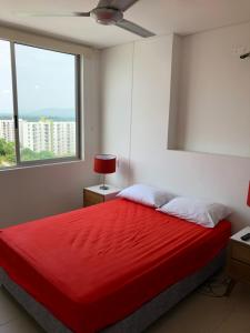 1 dormitorio con cama roja y ventana en Girardot Deluxe, en Girardot