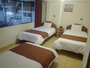 a hotel room with two beds and a window at MachuPicchu Dream in Machu Picchu