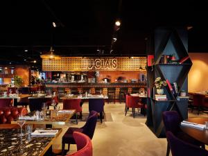 een restaurant met tafels en stoelen en een bar bij Cityden Stadshart in Amstelveen