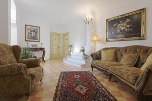 a living room with two couches and a painting on the wall at Atenea Luxury Suites - Atenea Collection in Agrigento