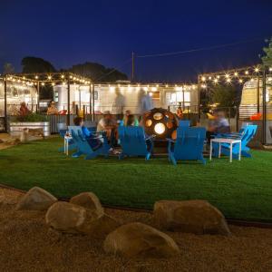 eine Gruppe von Menschen, die nachts auf einem Rasen auf Stühlen sitzen in der Unterkunft Waypoint Ventura in Ventura