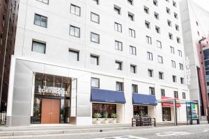 福岡的住宿－福岡東映酒店，城市街道上的白色建筑