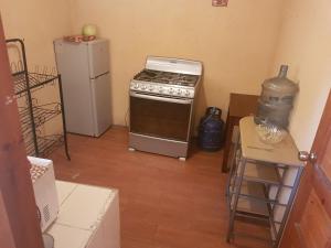 a kitchen with a stove and a refrigerator and a table at Río Apartment City Center in Quetzaltenango