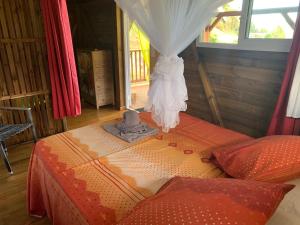 a room with a bed in a room with a window at Les Bungalows de la Sucrerie in Le François