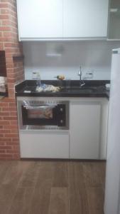 a kitchen with a stove and a sink in it at RESIDENCIA DOS LEAIS in Arraial do Cabo