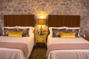 a bedroom with two beds and a lamp on a night stand at Luma B&B Boutique in Puebla