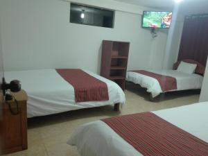 a hotel room with two beds and a tv at MachuPicchu Dream in Machu Picchu