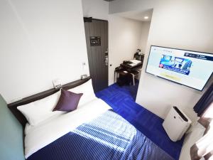 Postel nebo postele na pokoji v ubytování HOTEL LiVEMAX Hakataeki Minami