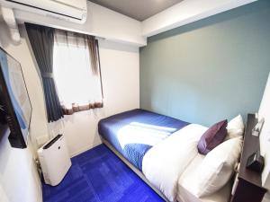 Postel nebo postele na pokoji v ubytování HOTEL LiVEMAX Hakataeki Minami