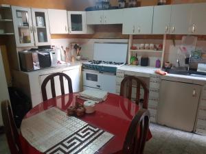 une petite cuisine avec une table rouge et une cuisinière dans l'établissement Río rooms in City Center, à Quetzaltenango