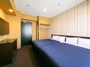 a hotel room with a bed and a television at HOTEL LiVEMAX Sendai Aobadori in Sendai