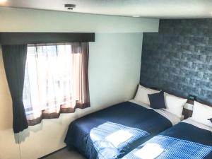 Postel nebo postele na pokoji v ubytování HOTEL LiVEMAX Okayama