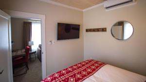 a hotel room with a bed and a mirror at Cranberry Arms Pub and Hotel in Nanaimo