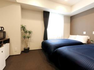 a bedroom with a blue bed and a window at HOTEL LiVEMAX Kayabacho in Tokyo