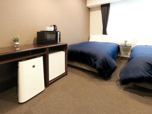 a hotel room with two beds and a tv at HOTEL LiVEMAX Kayabacho in Tokyo