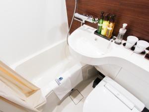 大阪市にあるホテルリブマックス心斎橋イーストの白いトイレと洗面台のあるバスルーム +17枚の写真