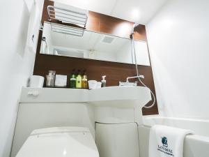 a bathroom with a sink and a toilet at HOTEL LiVEMAX Tokyo Shintomicho in Tokyo