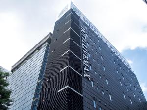 a tall black building with a sign on it at HOTEL LiVEMAX Meieki in Nagoya