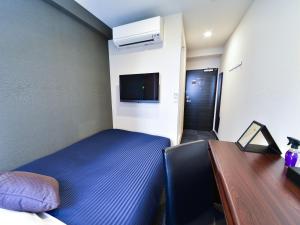 a bedroom with a bed and a desk and a tv at HOTEL LiVEMAX Toyosu-Ekimae in Tokyo