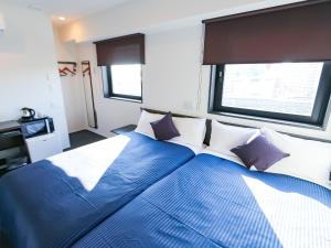 Un dormitorio con una gran cama azul con almohadas en HOTEL LiVEMAX Akabane-Ekimae, en Tokio