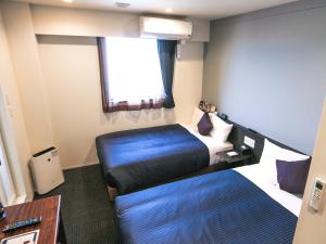 Postel nebo postele na pokoji v ubytování HOTEL LiVEMAX Tokyo Ayase-Ekimae