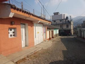 eine Gasse mit einem Gebäude mit einer weißen Tür in der Unterkunft Río rooms in City Center in Quetzaltenango