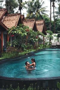 un uomo e una donna in acqua in una piscina di Gili One Resort a Gili Trawangan