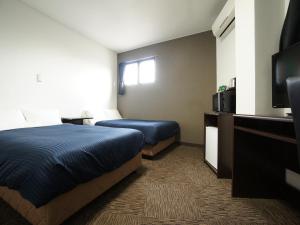En eller flere senge i et værelse på HOTEL LiVEMAX BUDGET Gunma Numata