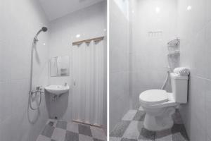 ein weißes Bad mit einem WC und einem Waschbecken in der Unterkunft SUPER OYO 478 Balcon Biru in Jakarta