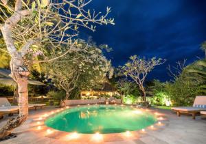 a swimming pool in a backyard at night at Aashaya Jasri Resort in Jasri