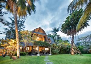 a house with a large building with palm trees at Aashaya Jasri Resort in Jasri +100 photos