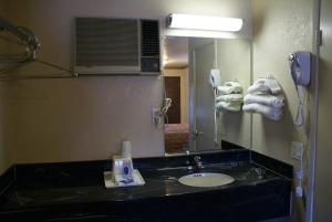 a bathroom with a sink and a mirror and a phone at Best Budget Inn Anaheim in Anaheim