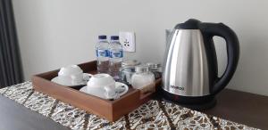 a tray with a coffee maker and bottles of water at Kyumari in Ubud