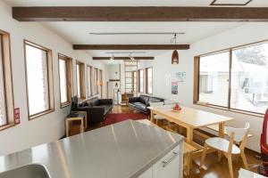 una cucina e un soggiorno con tavolo e sedie di Nozawa Cottage a Nozawa Onsen