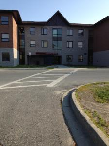 un aparcamiento vacío frente a un edificio en Residence & Conference Centre - Sudbury North en Sudbury