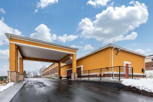a large yellow building with an overpass at Quality Inn Coraopolis in Coraopolis