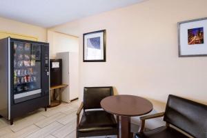 a room with a table and chairs and a refrigerator at Rodeway Inn Sergeant Bluff - Sioux City in Sergeant Bluff